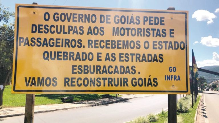 POLÊMICA: GOVERNO CAIADO INSTALA PLACA PEDINDO DESCULPAS AOS MOTORISTAS PELOS BURACOS NA PISTA PRÓXIMO DE PIRENÓPOLIS; MENSAGEM AFIRMA QUE GOVERNADOR RECEBEU ESTADO QUEBRADO