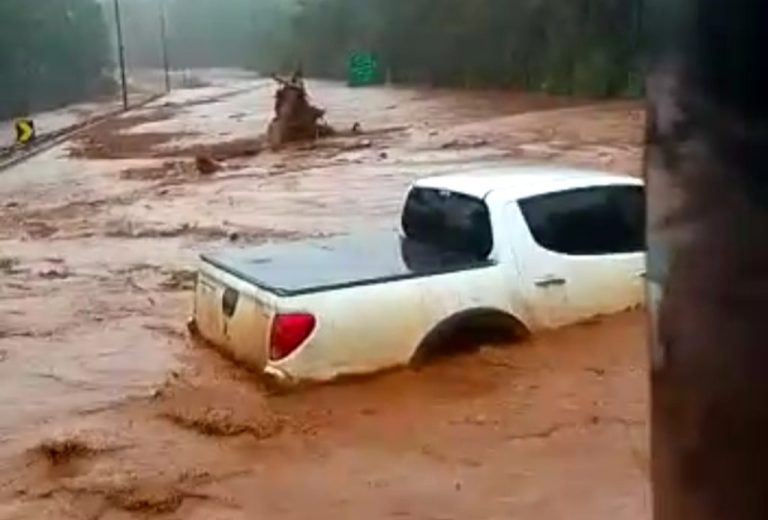 Dique de barragem transborda e motorista filma caminhonete rodando em lamaçal, em MG