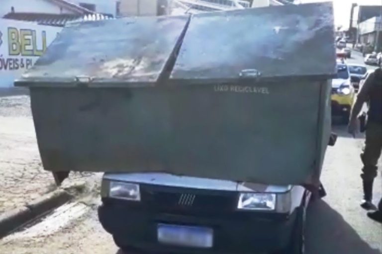 Motorista carrega lixeira imensa no capô do carro, em Curitiba: “mas eu tava enxergando bem”